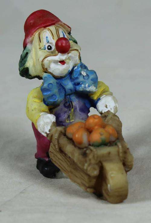 Miniature clown pushing a wheelbarrow