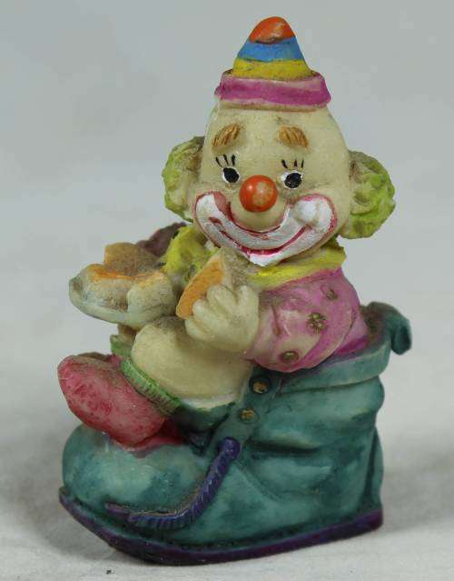 Miniature clown sitting in a shoe