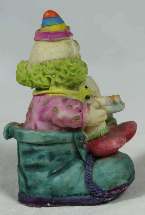 Miniature clown sitting in a shoe