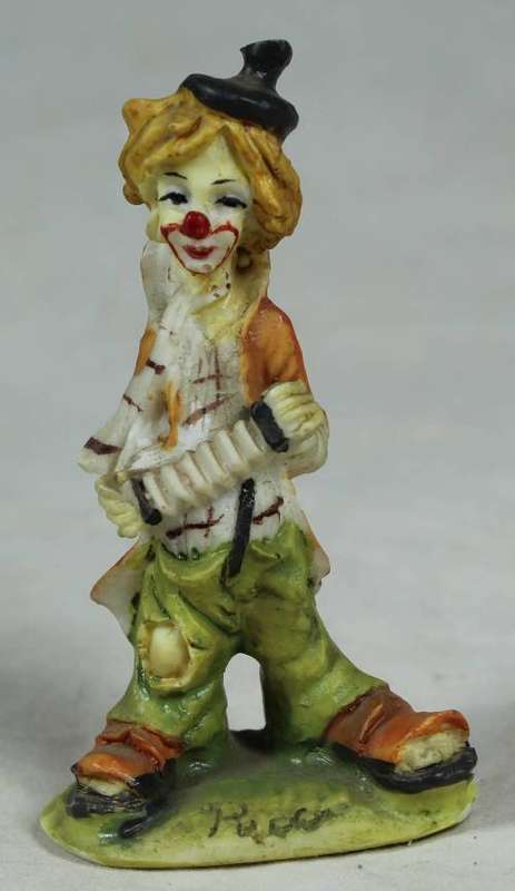 Miniature clown playing a concertina
