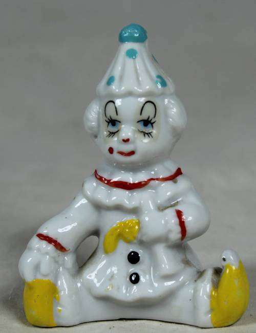 Miniature clown seated with yellow shoes