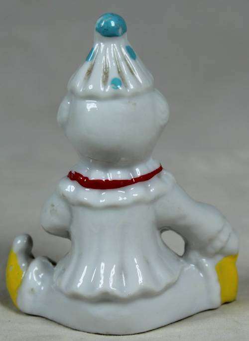 Miniature clown seated with yellow shoes