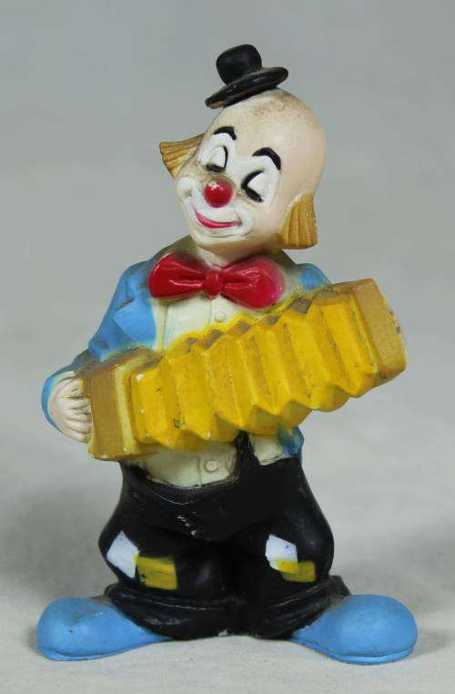 Miniature clown playing a yellow concertina