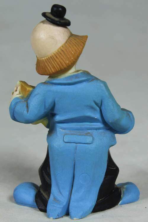 Miniature clown playing a yellow concertina