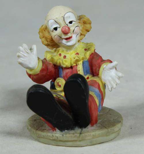 Miniature seated clown with arms stretched open