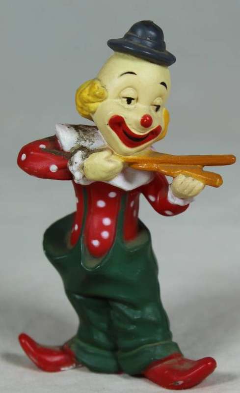Miniature clown playing with sticks