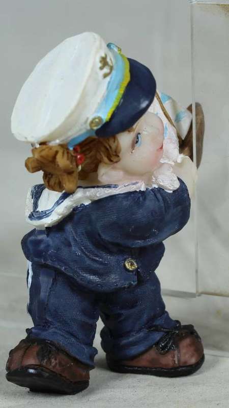 Kid sailor in blue holding a sail boat