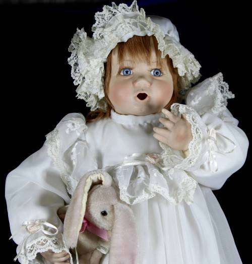 Porcelain doll - baby holding rabbit on stand