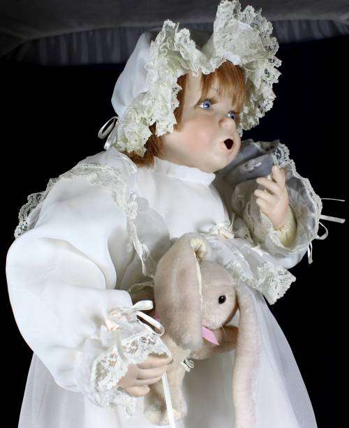 Porcelain doll - baby holding rabbit on stand
