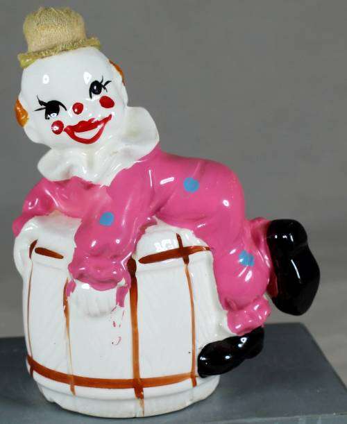 Clown figurine lying on a barrel