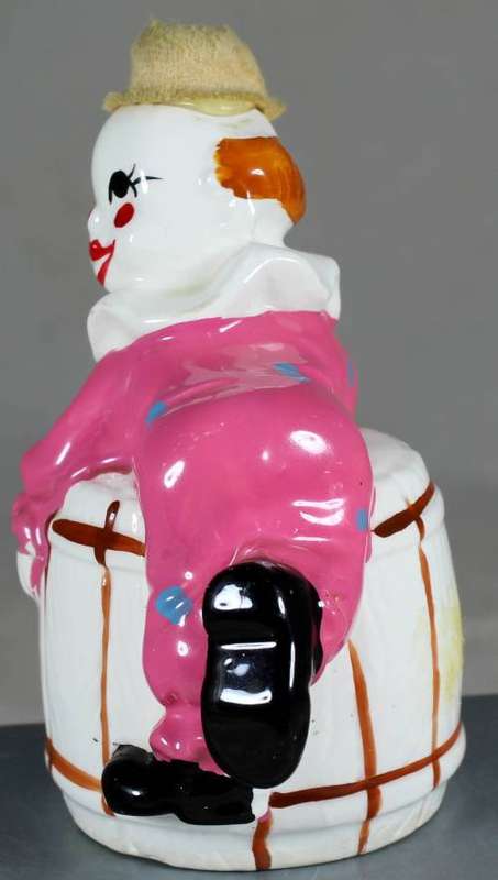 Clown figurine lying on a barrel