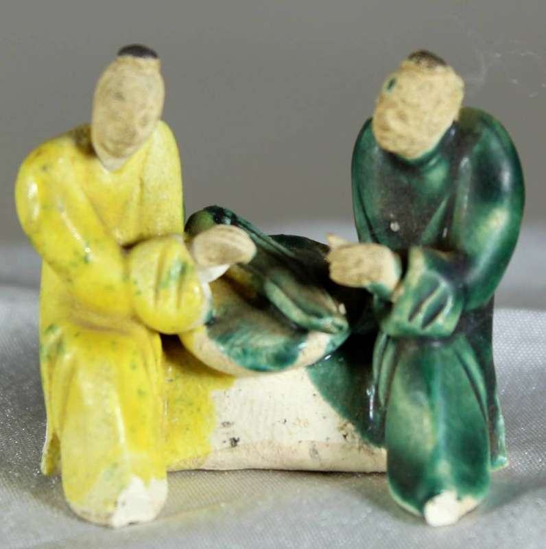 Miniature mudmen seated at table