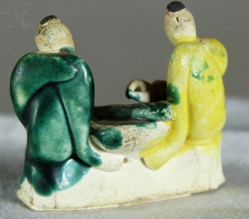 Miniature mudmen seated at table