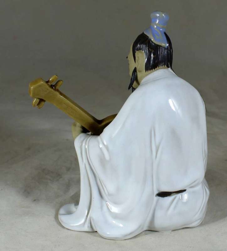 Mud man sitting with guitar
