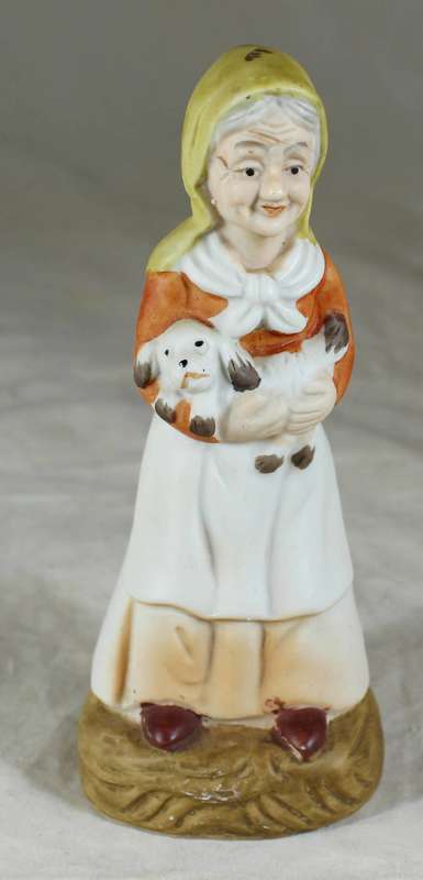 Old woman standing with dog in arms