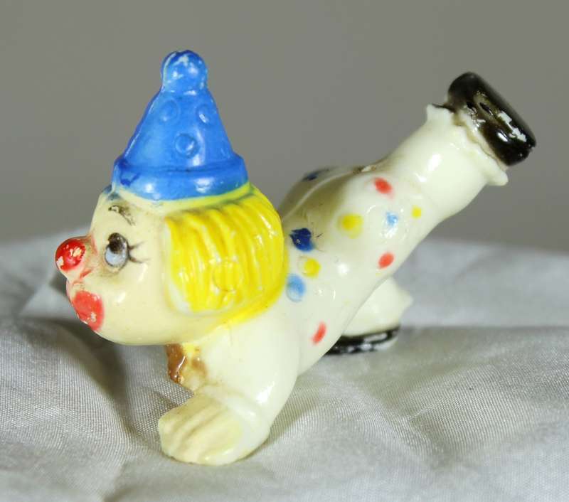 Miniature clown on stomach with leg in the air