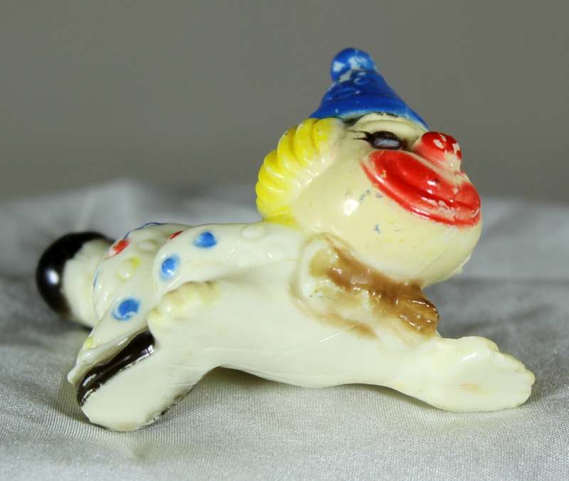 Miniature clown on stomach with leg in the air