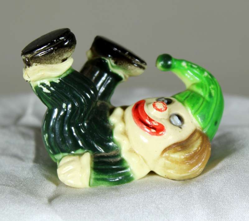Miniature clown on back with legs in the air
