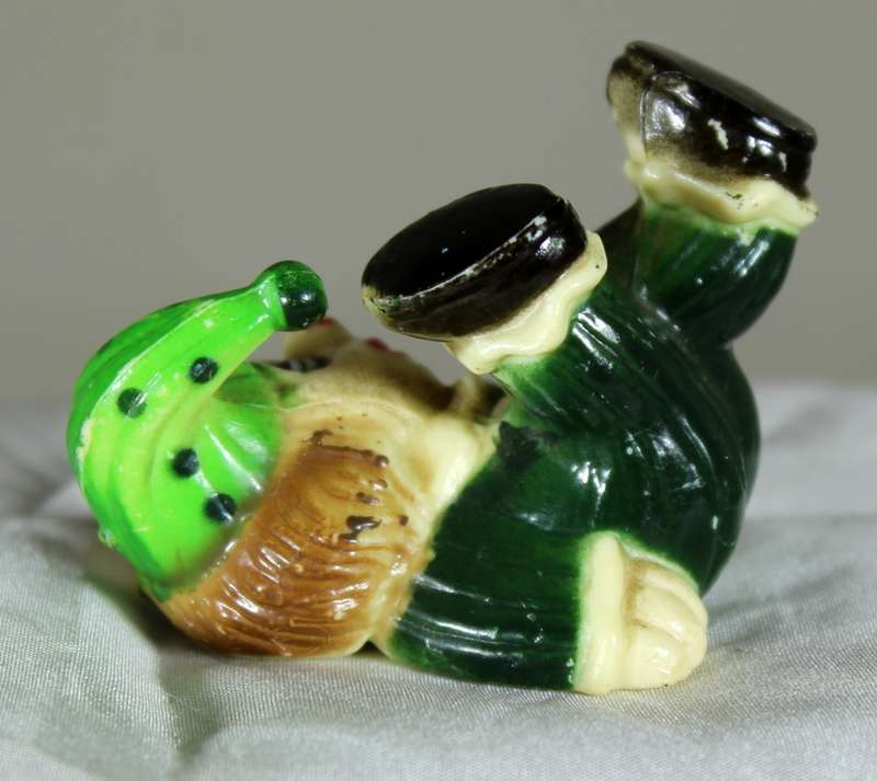 Miniature clown on back with legs in the air