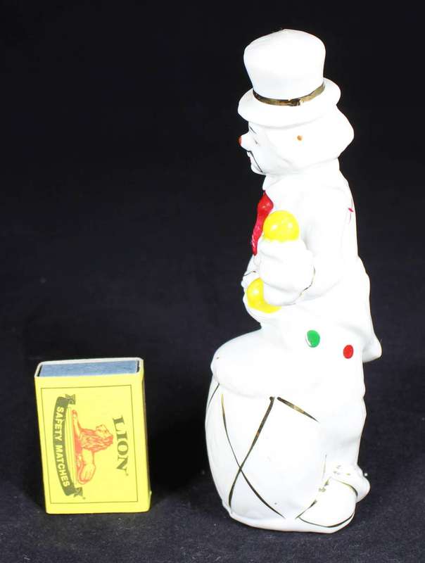 Porcelain clown beating a drum