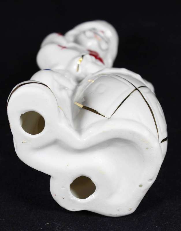 Porcelain clown beating a drum