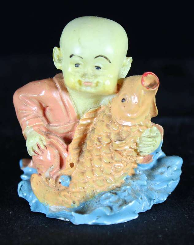 Little monk sitting with fish
