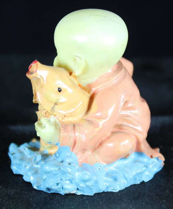 Little monk sitting with fish
