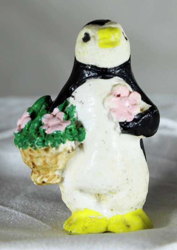 Vintage molded penguin holding flowers