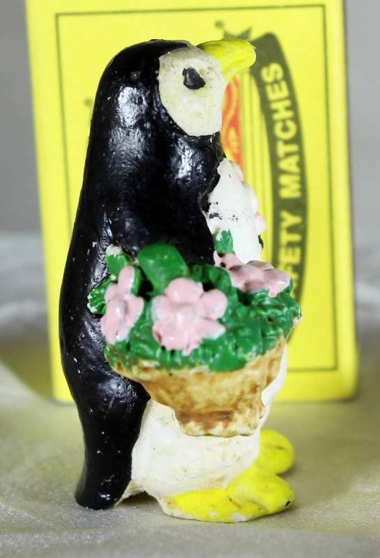 Vintage molded penguin holding flowers