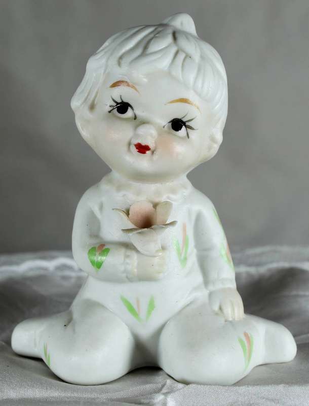 Porcelain little girl holding a flower