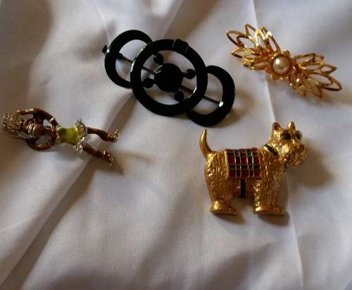 A set of 4 Vintage brooches- all are very unique and very pretty in design - see pics