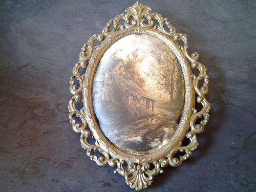 A vintage Brass Filigree frame with a satin padded 1900 stone farm house  setting. So ornate.