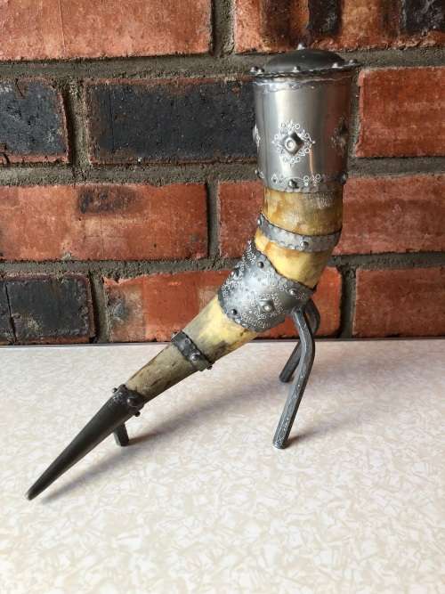 A pewter mounted powder horn with removable top, with engravings and embossed decoration