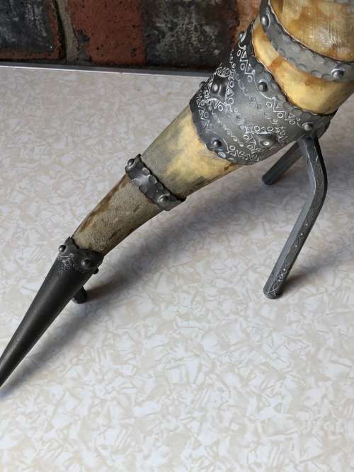 A pewter mounted powder horn with removable top, with engravings and embossed decoration