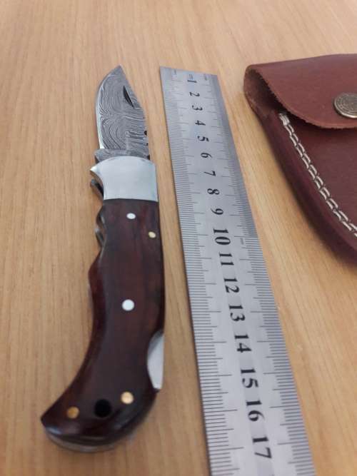 Handmade Damascus steel folding knife with Wooden handle scales.
