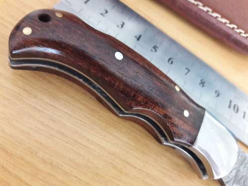 Handmade Damascus steel folding knife with Wooden handle scales.