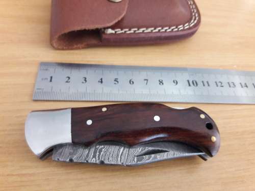 Handmade Damascus steel folding knife with Wooden handle scales.