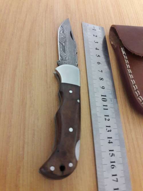 Handmade Damascus steel folding knife with Wooden handle scales.