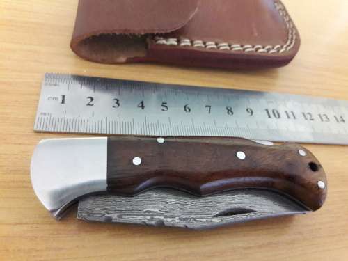 Handmade Damascus steel folding knife with Wooden handle scales.