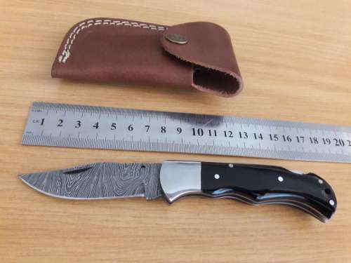 Handmade Damascus steel folding knife with BULL HORN handle scales.