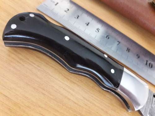 Handmade Damascus steel folding knife with BULL HORN handle scales.