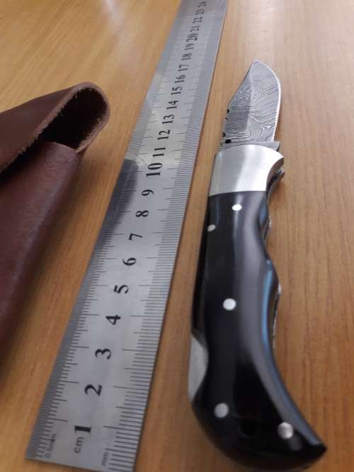 Handmade Damascus steel folding knife with BULL HORN handle scales.