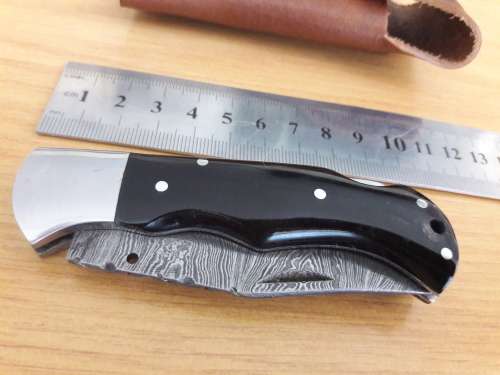 Handmade Damascus steel folding knife with BULL HORN handle scales.