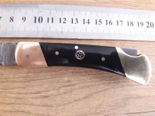 Handmade Damascus steel folding knife with Bull Horn handle scales.
