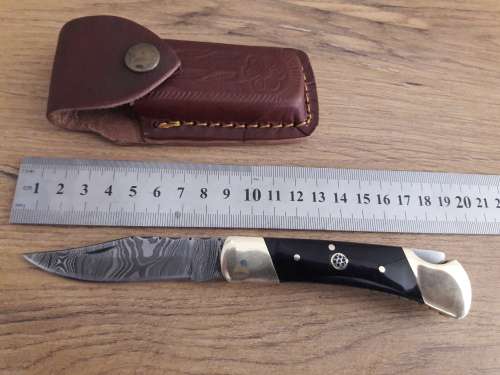Handmade Damascus steel folding knife with Bull Horn handle scales.