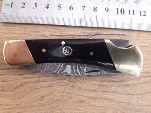 Handmade Damascus steel folding knife with Bull Horn handle scales.