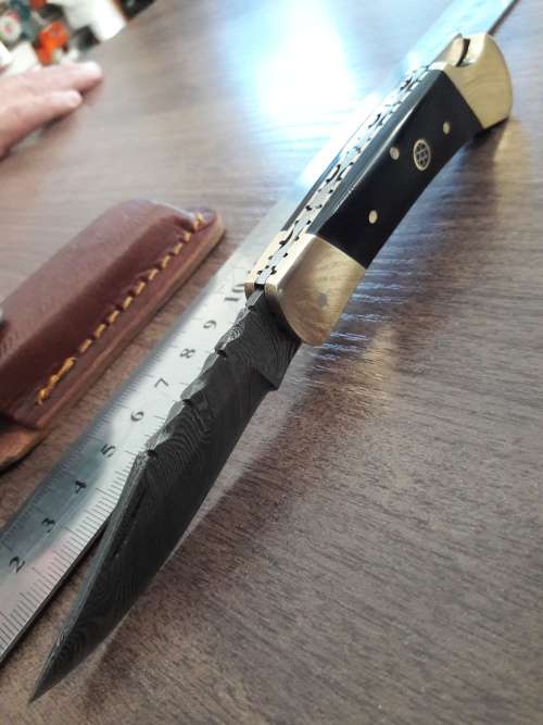 Handmade Damascus steel folding knife with Bull Horn handle scales.