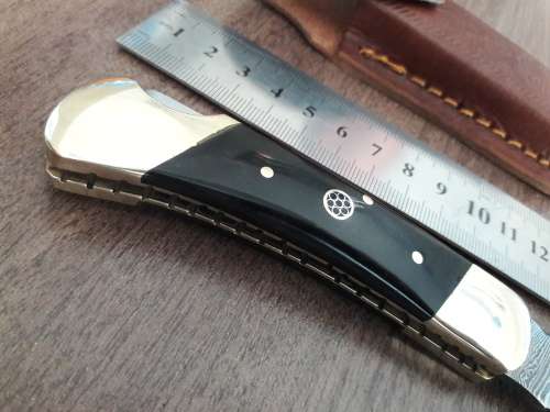 Handmade Damascus steel folding knife with Bull Horn handle scales.