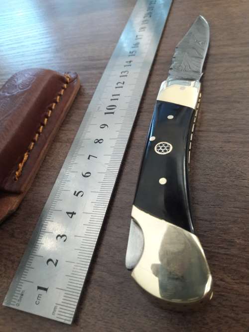 Handmade Damascus steel folding knife with Bull Horn handle scales.