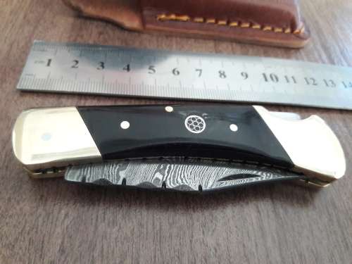 Handmade Damascus steel folding knife with Bull Horn handle scales.